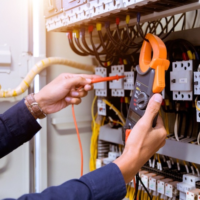 An electrician tinkering with an electricity panel