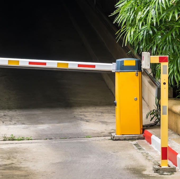 A large commercial automatic gate is shown and is the entrance to the parking garage.