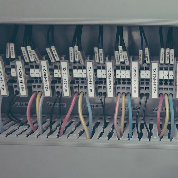 A control panel is brought into view. It has many different cords and switches aligned in a row.